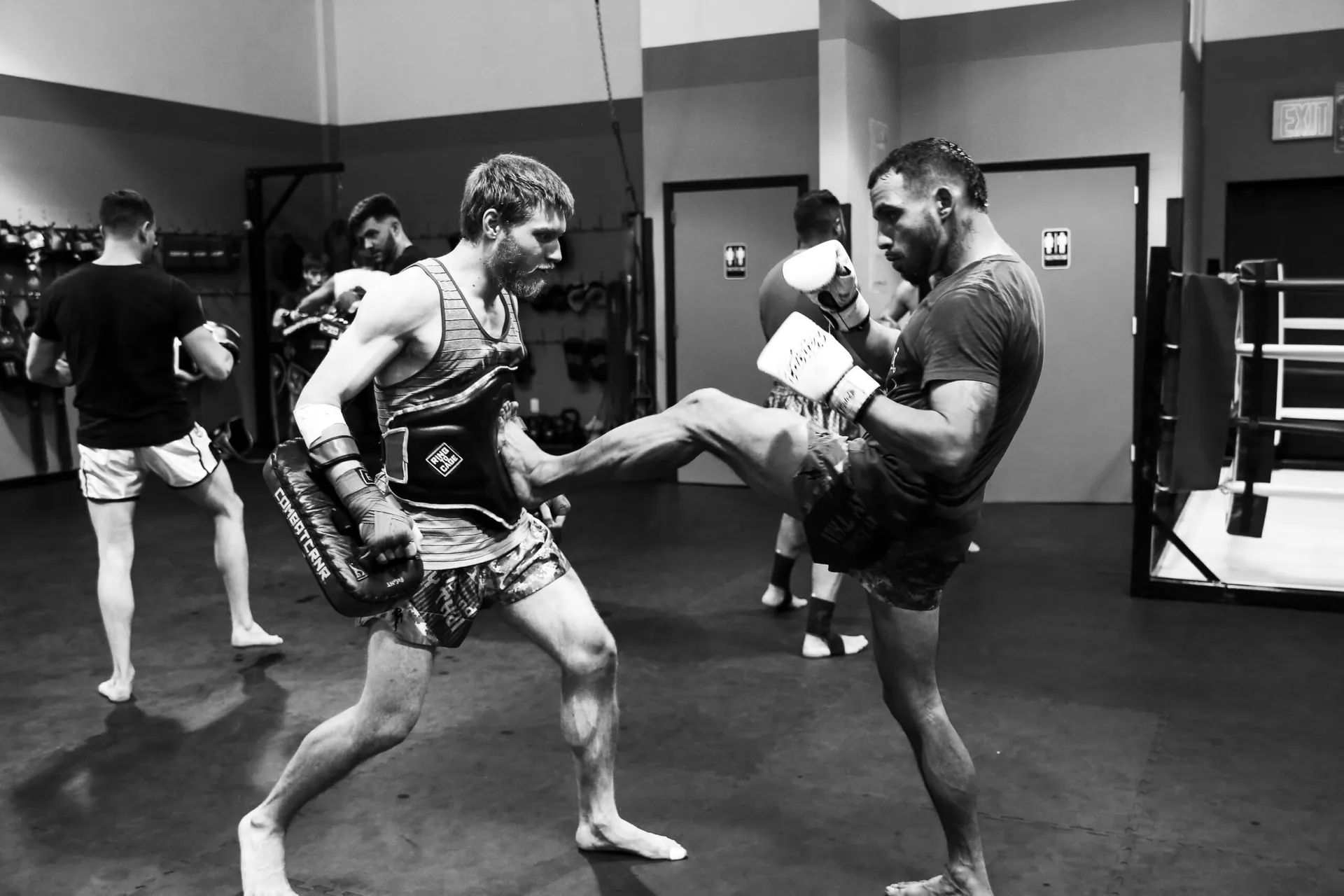 Adult Muay Thai practitioners training with focus mitts